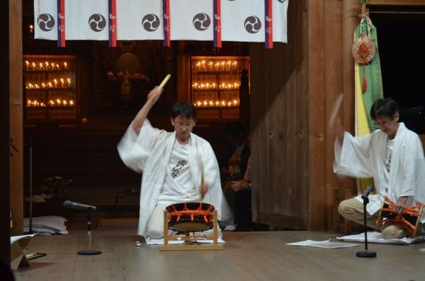 白色の法被姿の男性2名が締太鼓、小鼓をそれぞれ叩いて演奏している写真